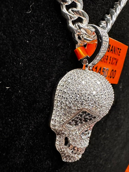 Silver skull pendant necklace on a black stand with an orange tag.