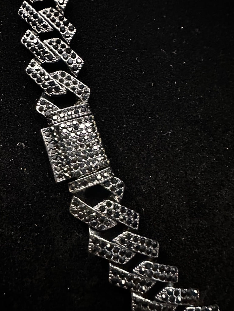 Silver bracelet with diamond-like stones on a black background