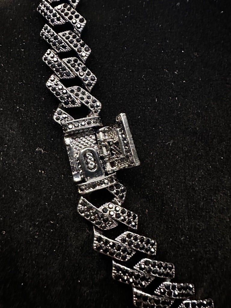 Silver bracelet with a clasp on a black background