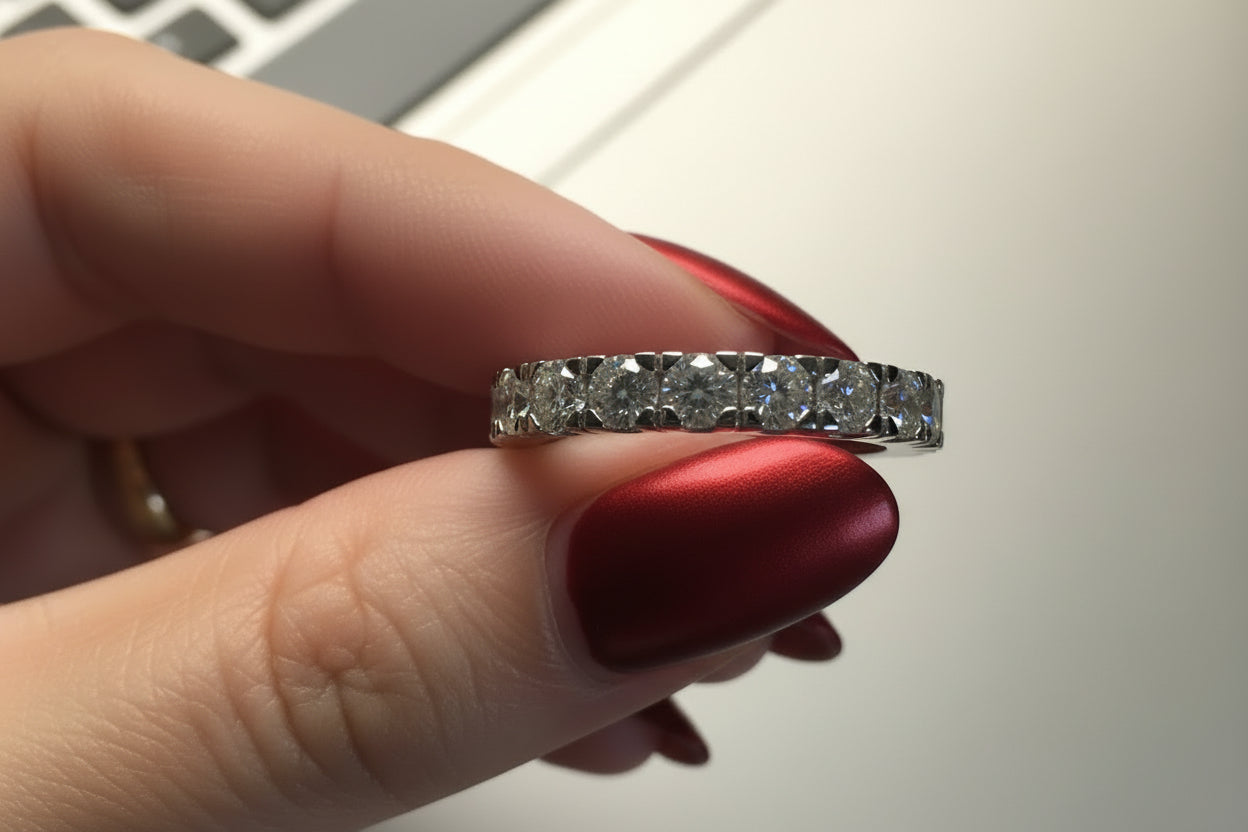 Close-up of a hand holding a diamond ring with a blurred background