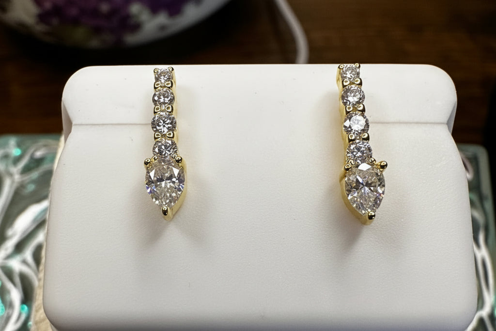 Two diamond rings on a white stand with a quarter for scale.