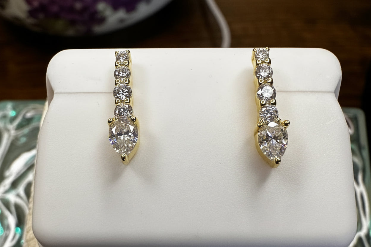 Two diamond rings on a white stand with a quarter for scale.