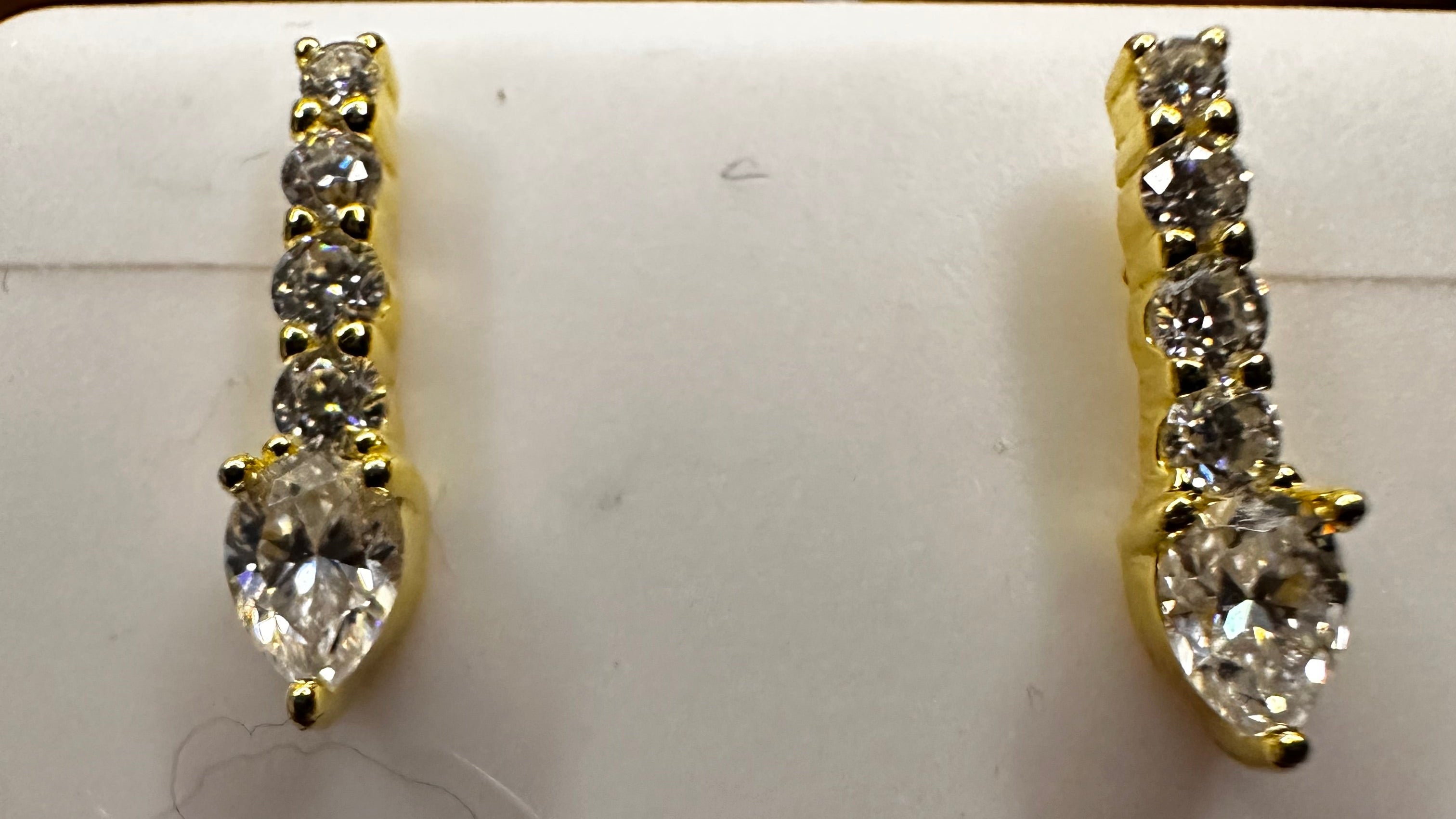 Gold and diamond ring on a white card with a coin for scale.