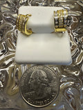 Two gold rings on a white stand with a quarter dollar coin below.