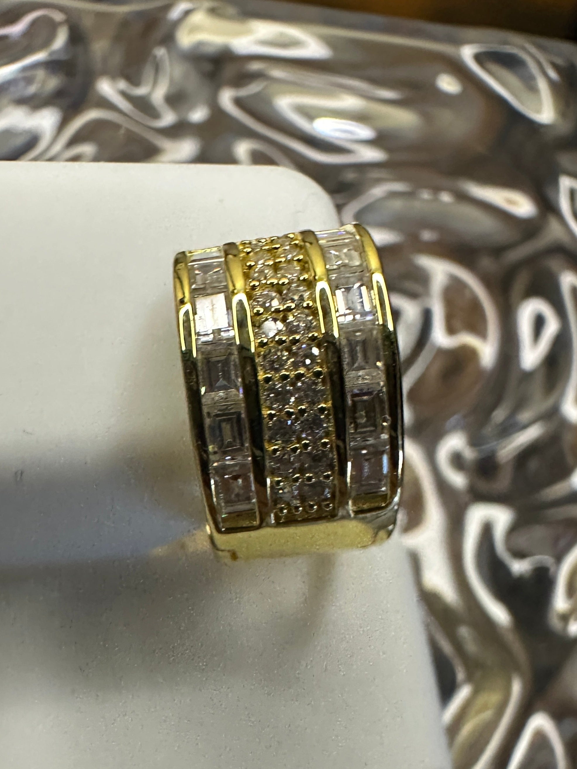 Gold ring with diamond accents on a white stand