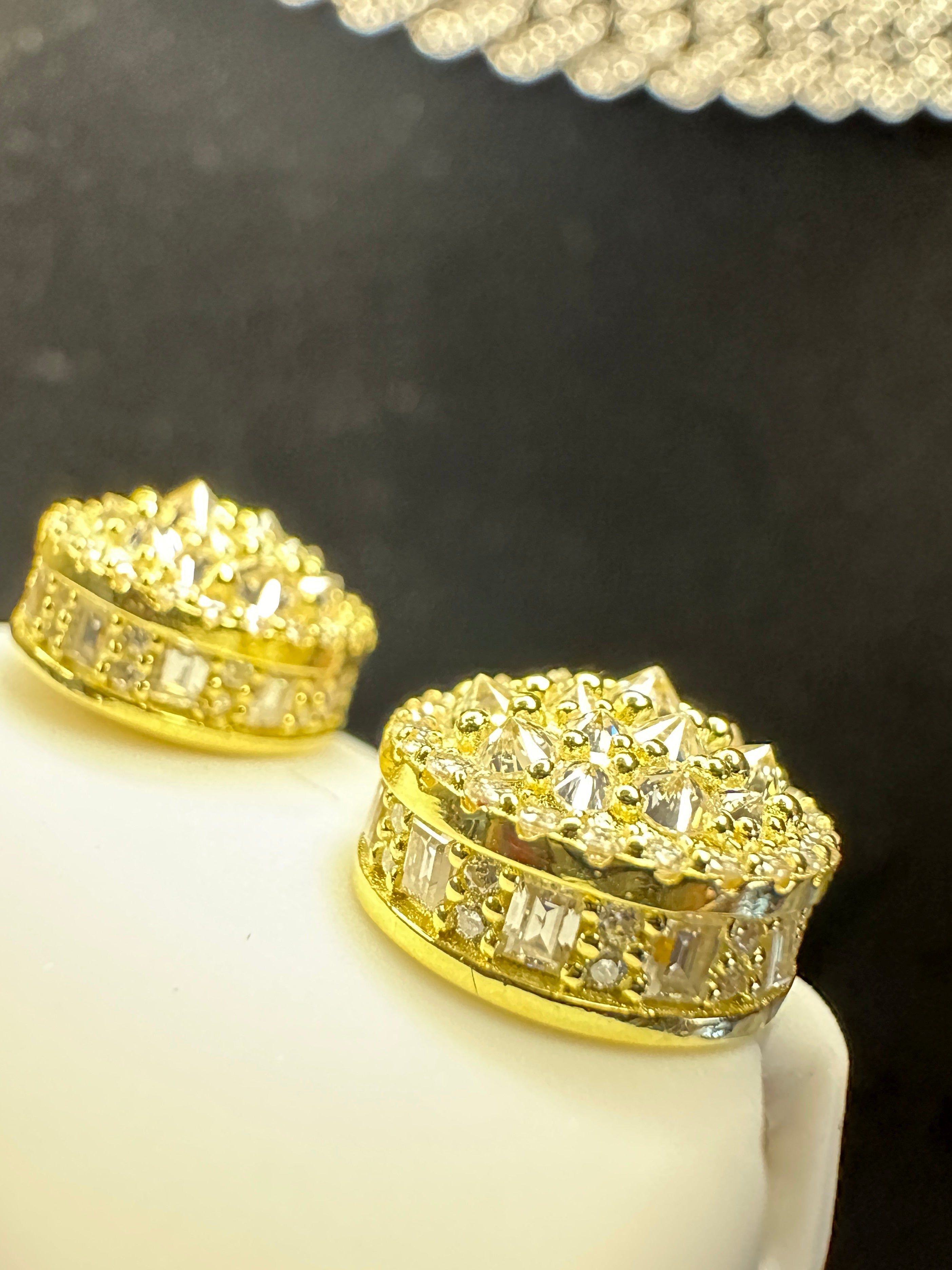 Gold earrings with lab grown diamonds on a black background