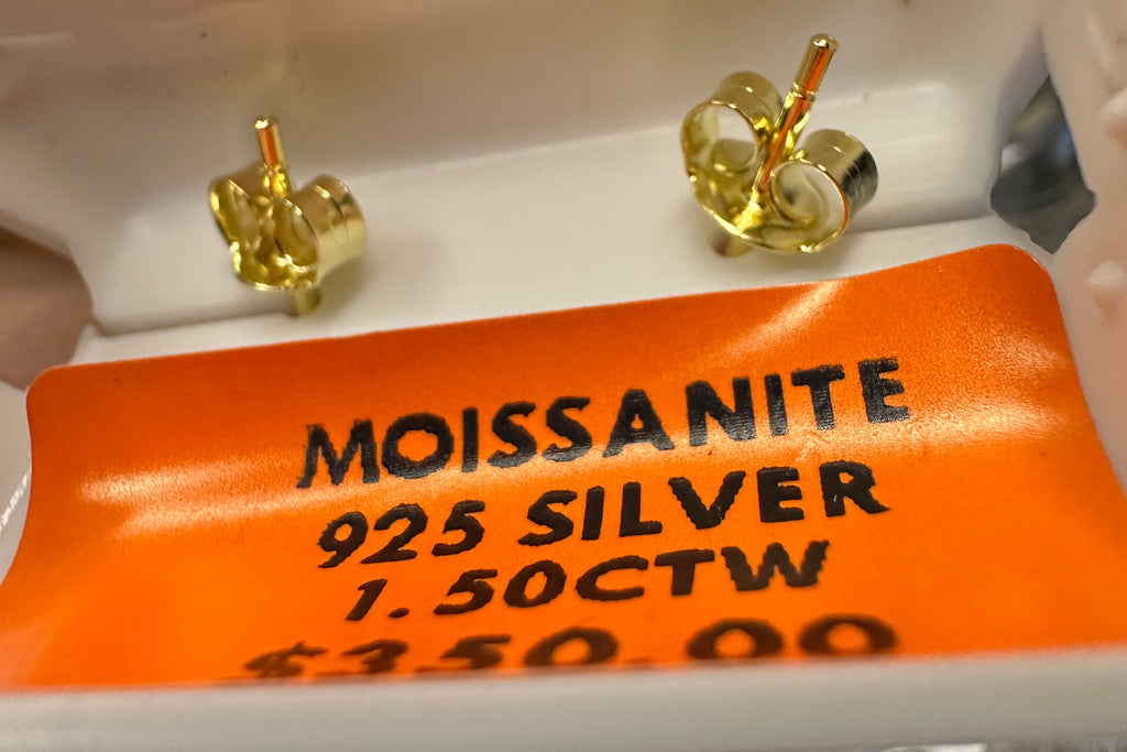 Gold earrings on a display card with 'Moissanite' and '925 Silver' text.