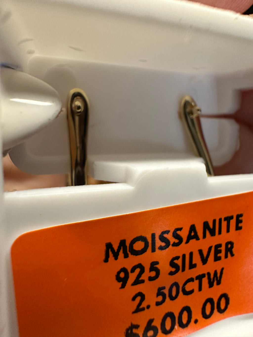 Close-up of a jewelry label with 'Moissanite', '925 Silver', '2.50CTW', and price information.