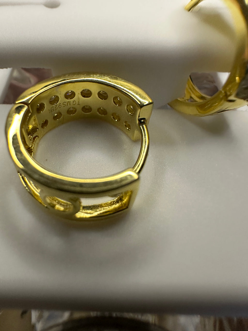 Gold hoop earrings on a white surface