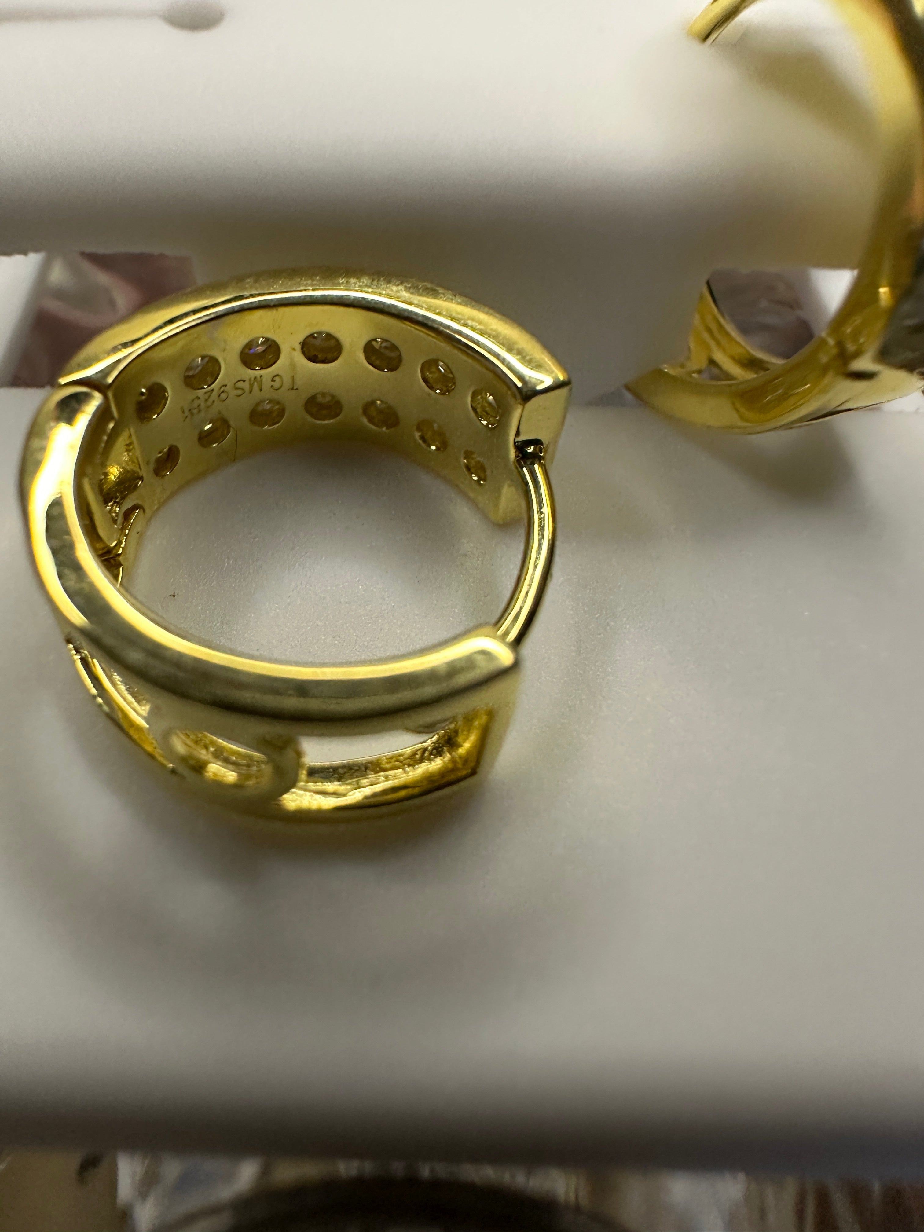 Gold hoop earrings on a white surface