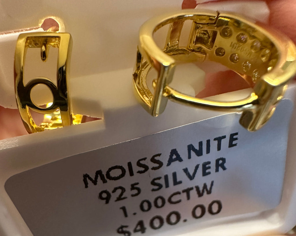 Gold earrings on a display card with 'Moissanite' and '925 Silver' information.