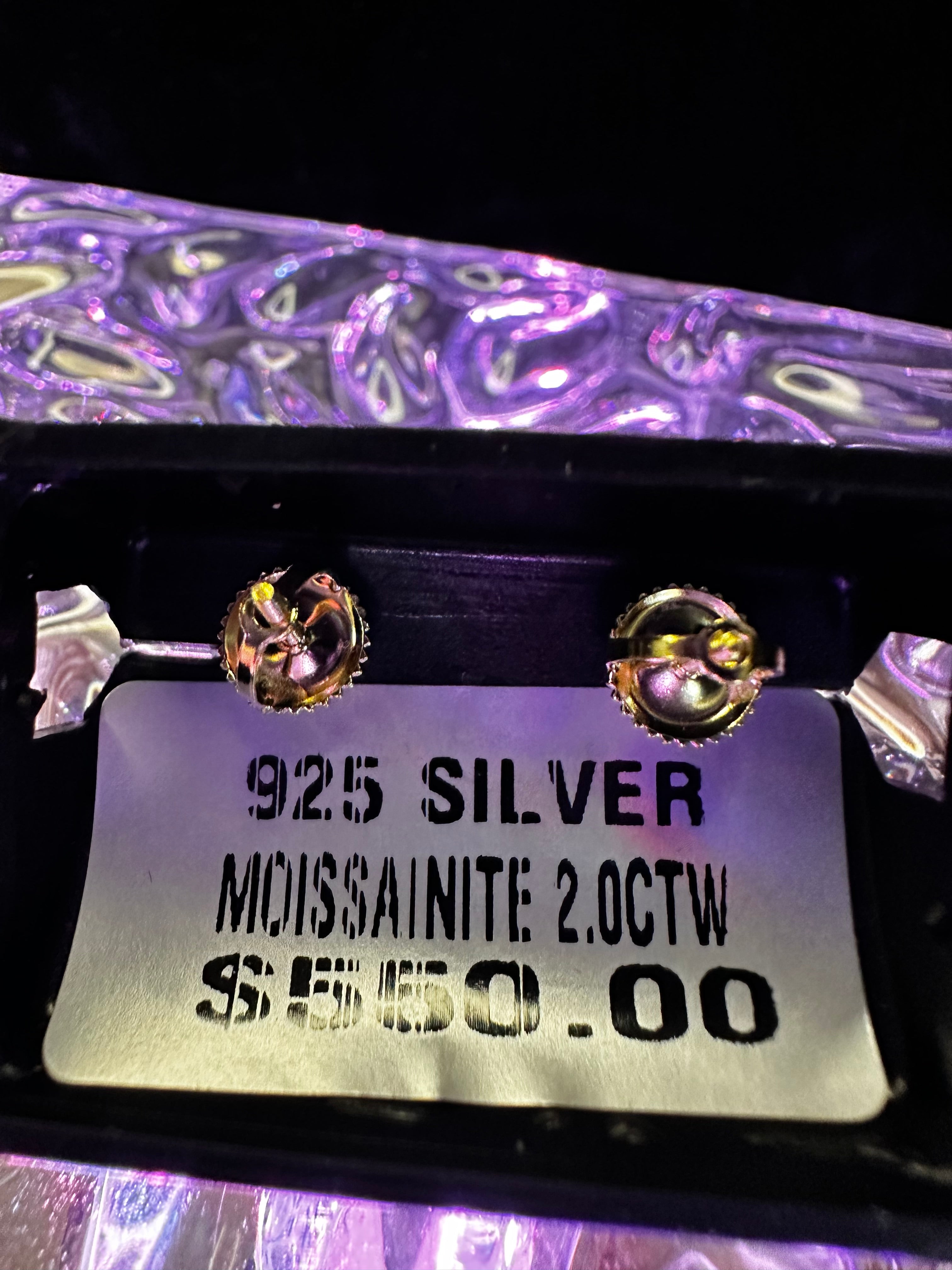 Close-up of silver earrings with a label on a dark background