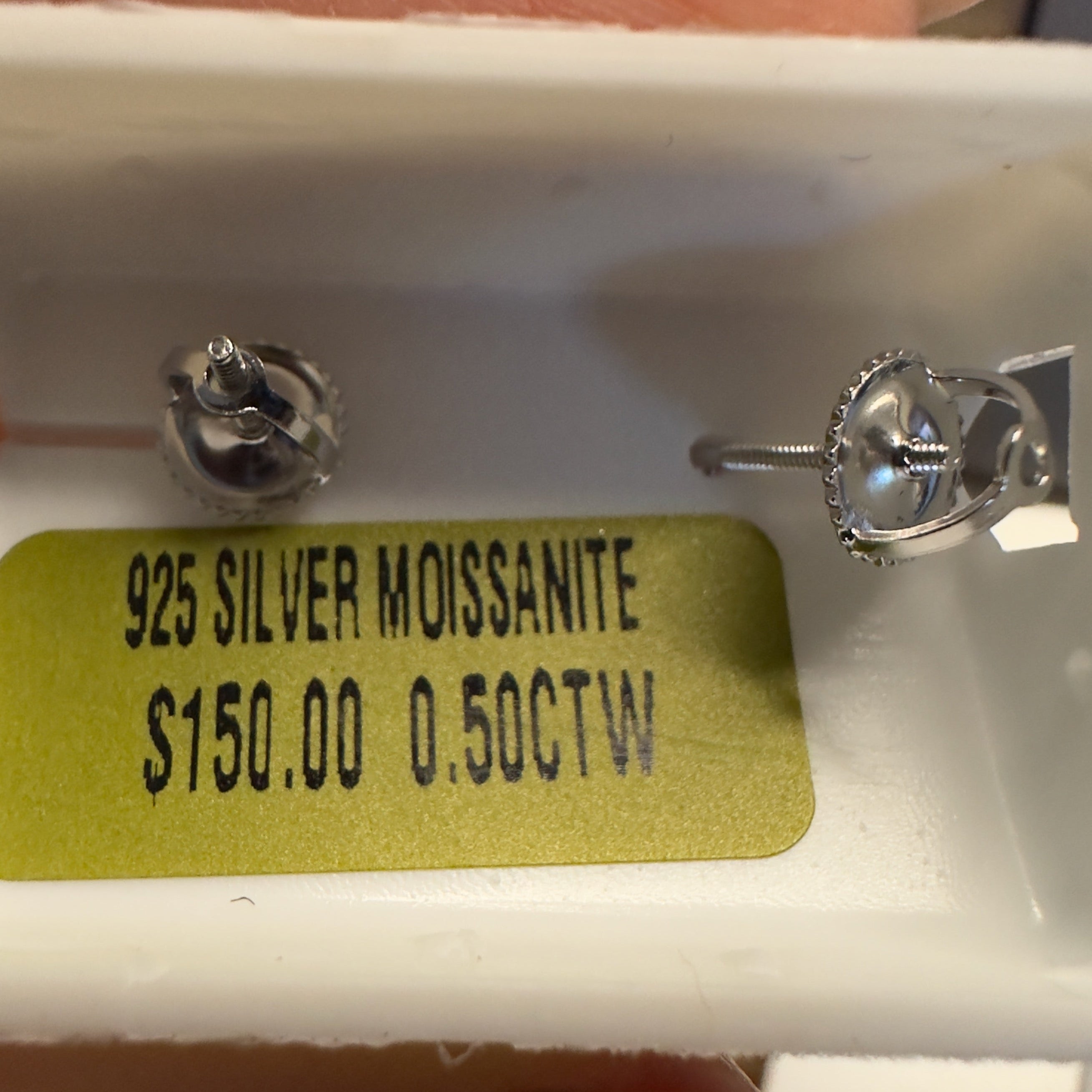 Diamond earrings with a gold tag displaying '925 Silver Moissanite' and price information.