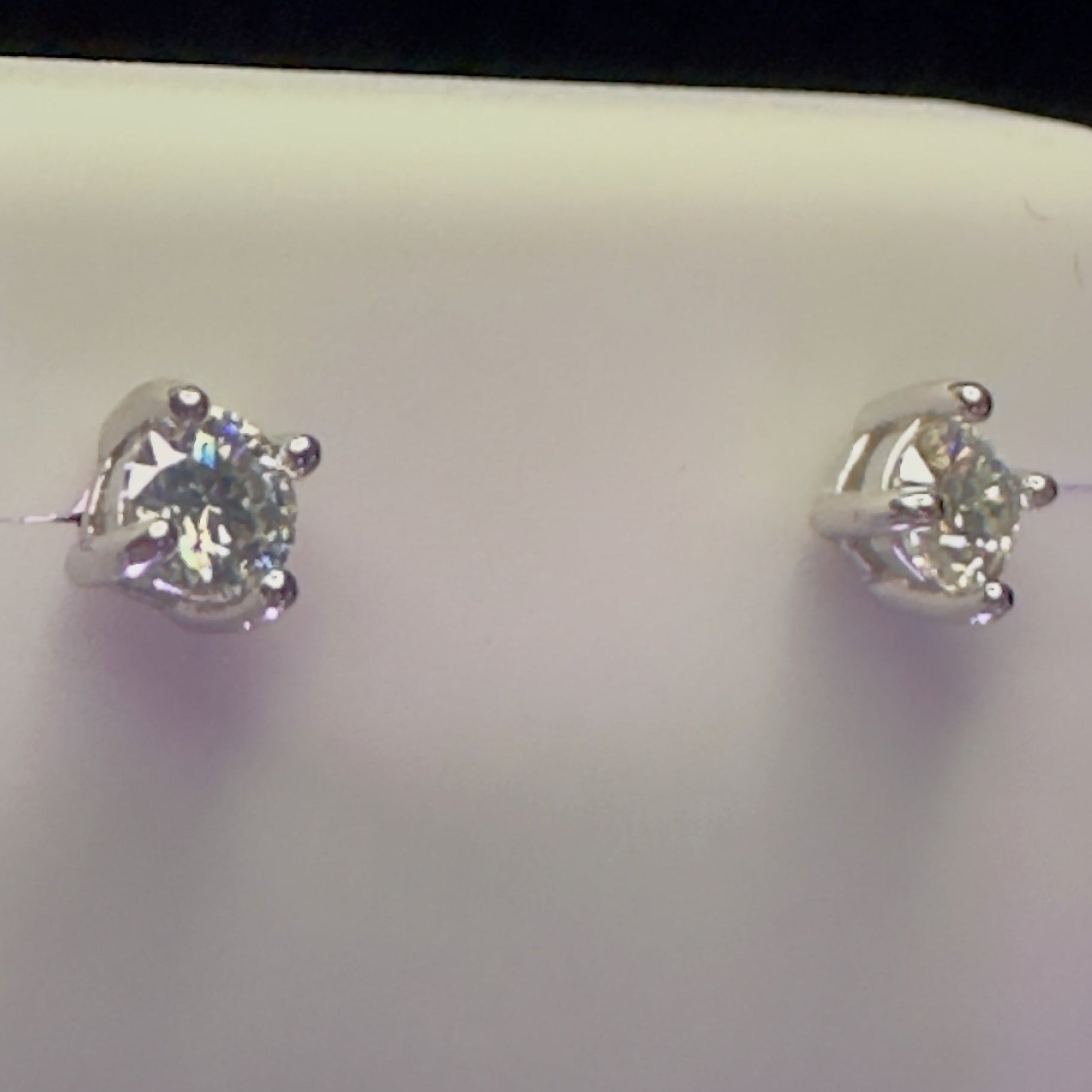 Silver stud earrings on a white card with a dark background