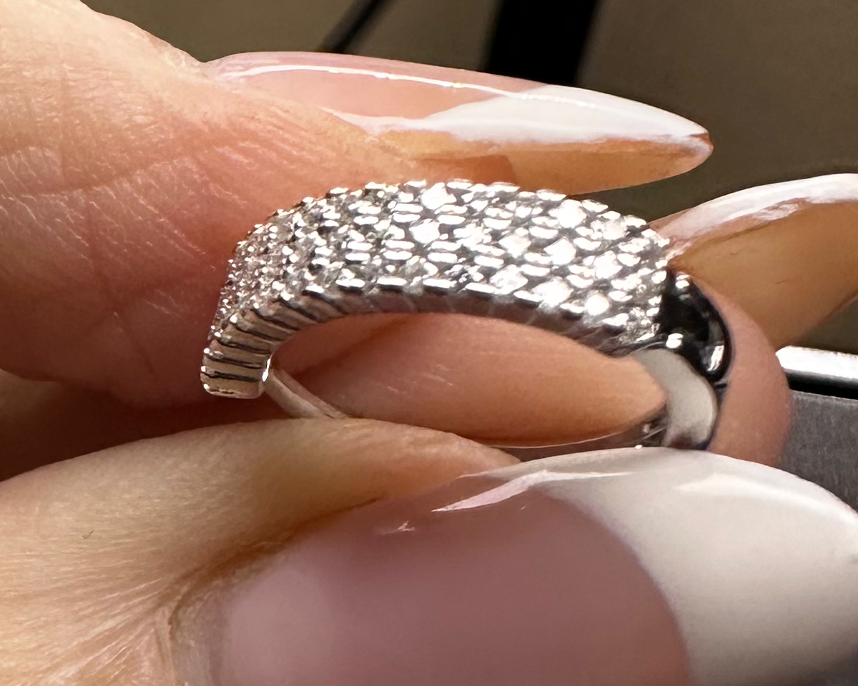 Hand wearing two rings with a Shopify app on a smartphone screen.