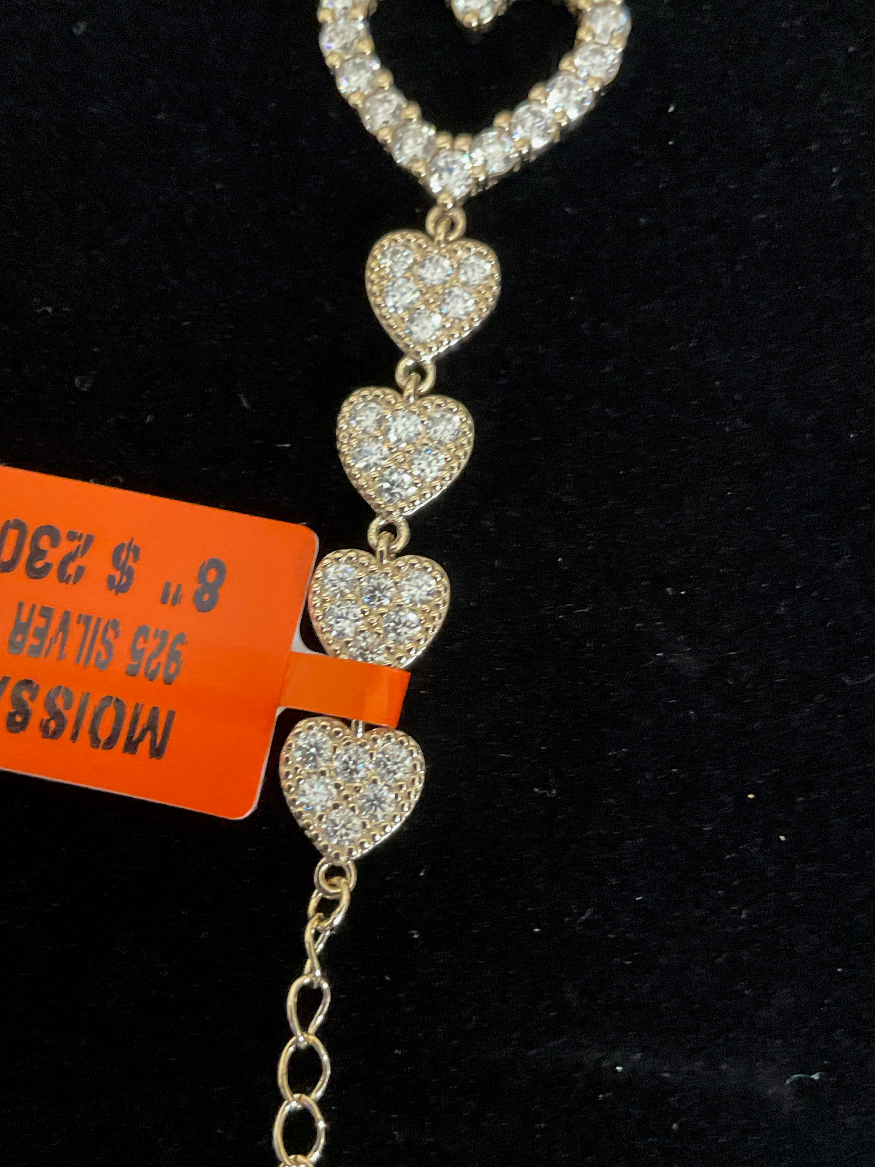 Gold necklace with heart-shaped pendants on a black background