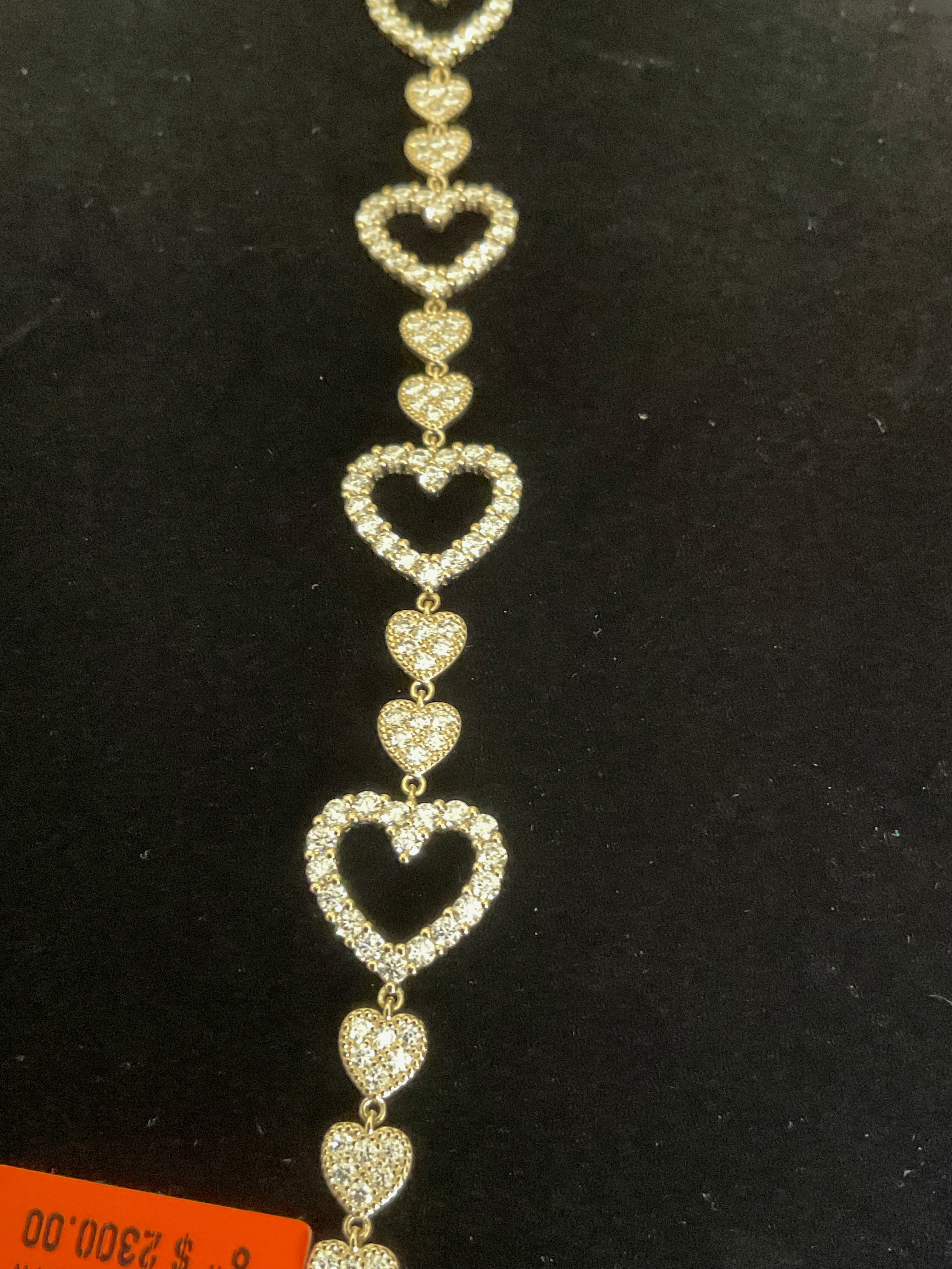 Gold heart-shaped bracelet on a black background