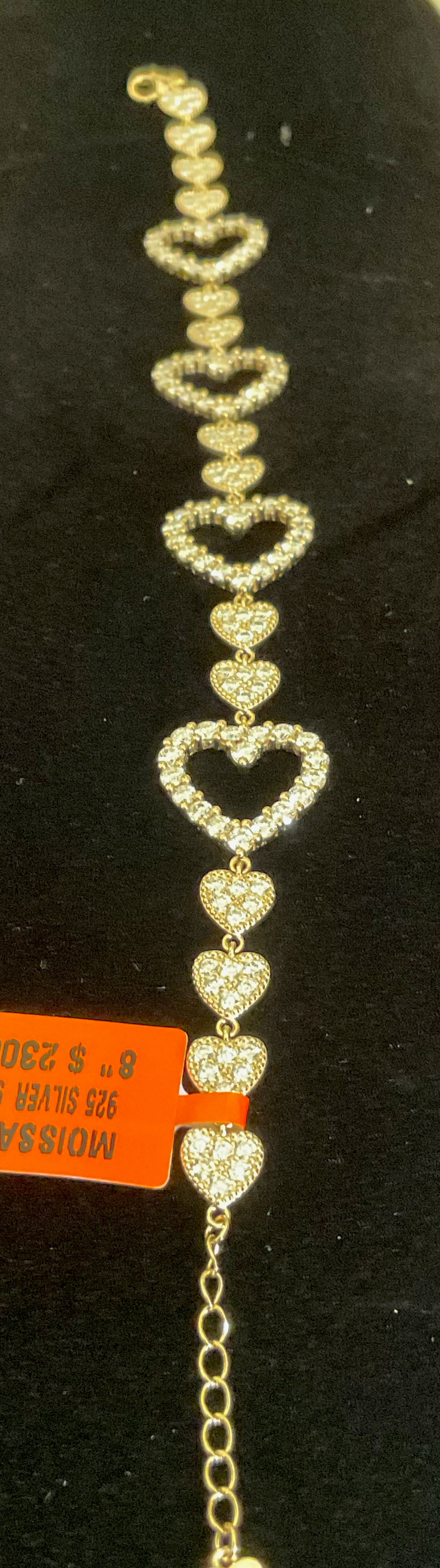 Heart-shaped bracelet with clear stones on a black background