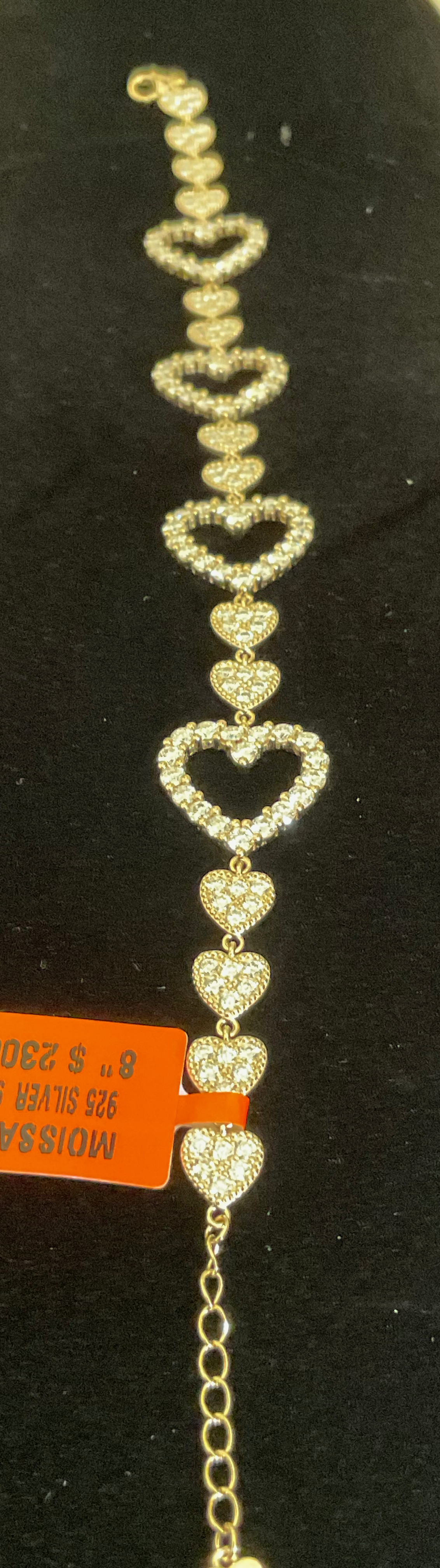 Heart-shaped bracelet with clear stones on a black background