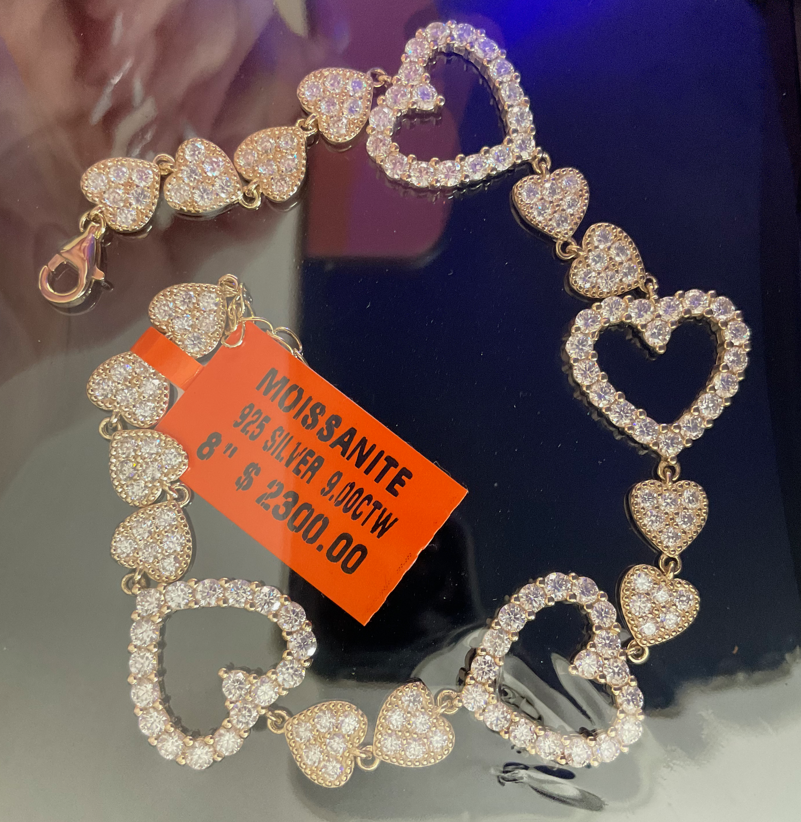 Heart-shaped bracelet with a price tag on a reflective surface