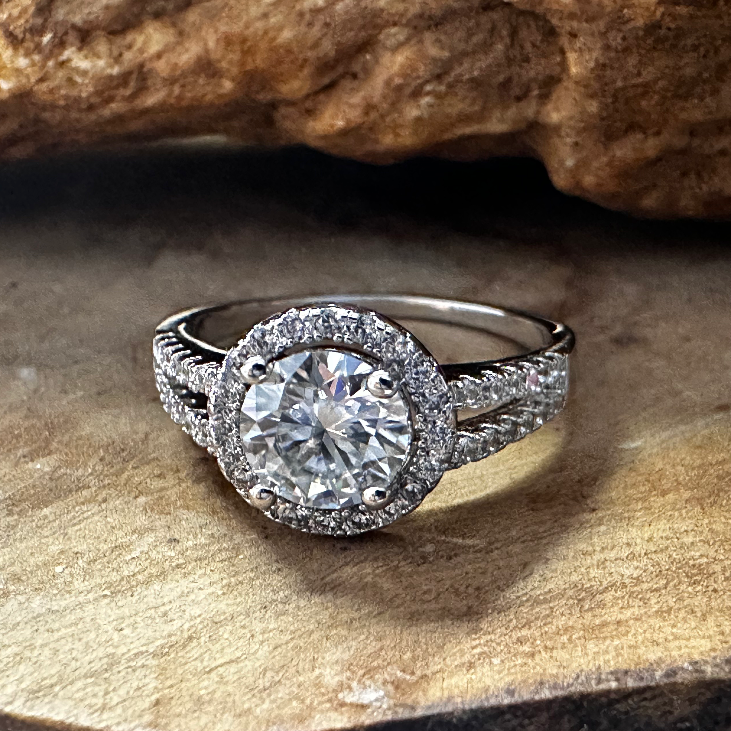 Diamond ring on a wooden surface with a rock in the background