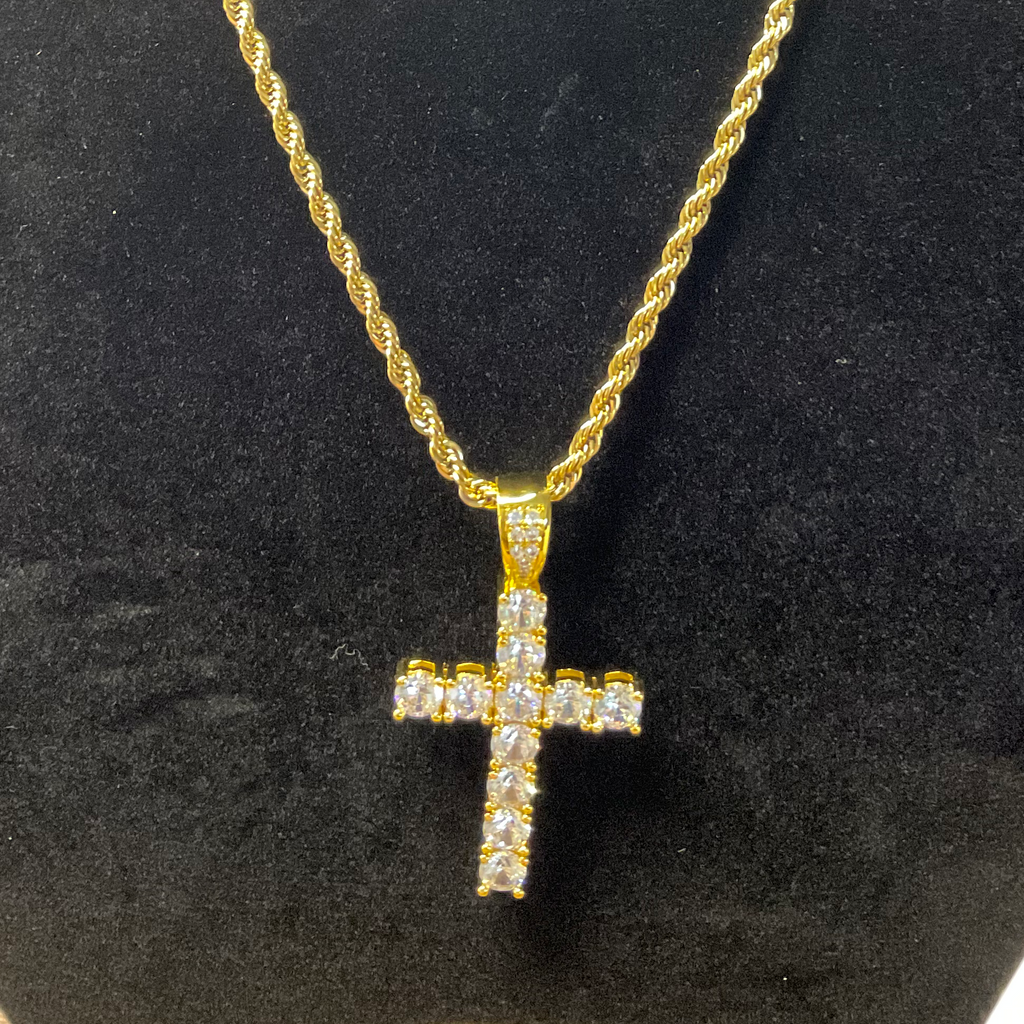 Gold cross necklace on a black stand