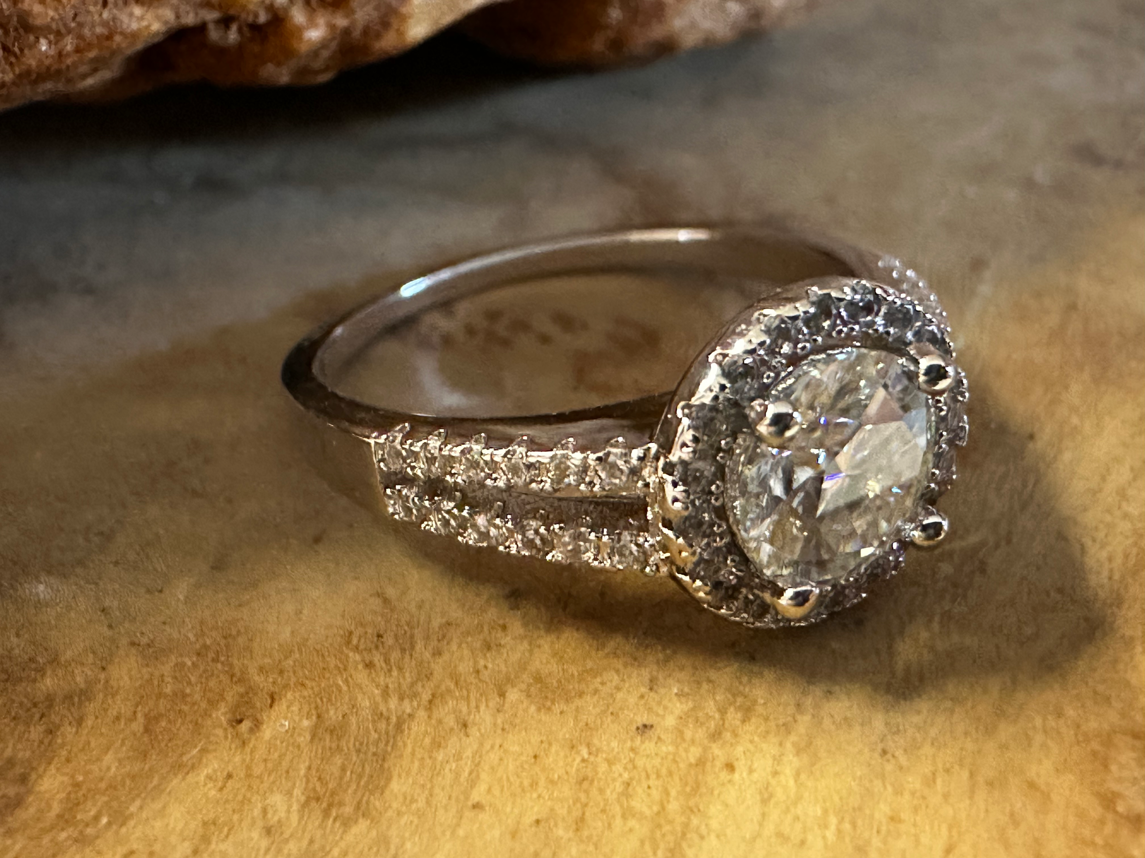 Diamond ring with a heart-shaped center stone on a textured surface