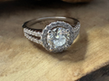Silver ring with a large diamond on a wooden surface