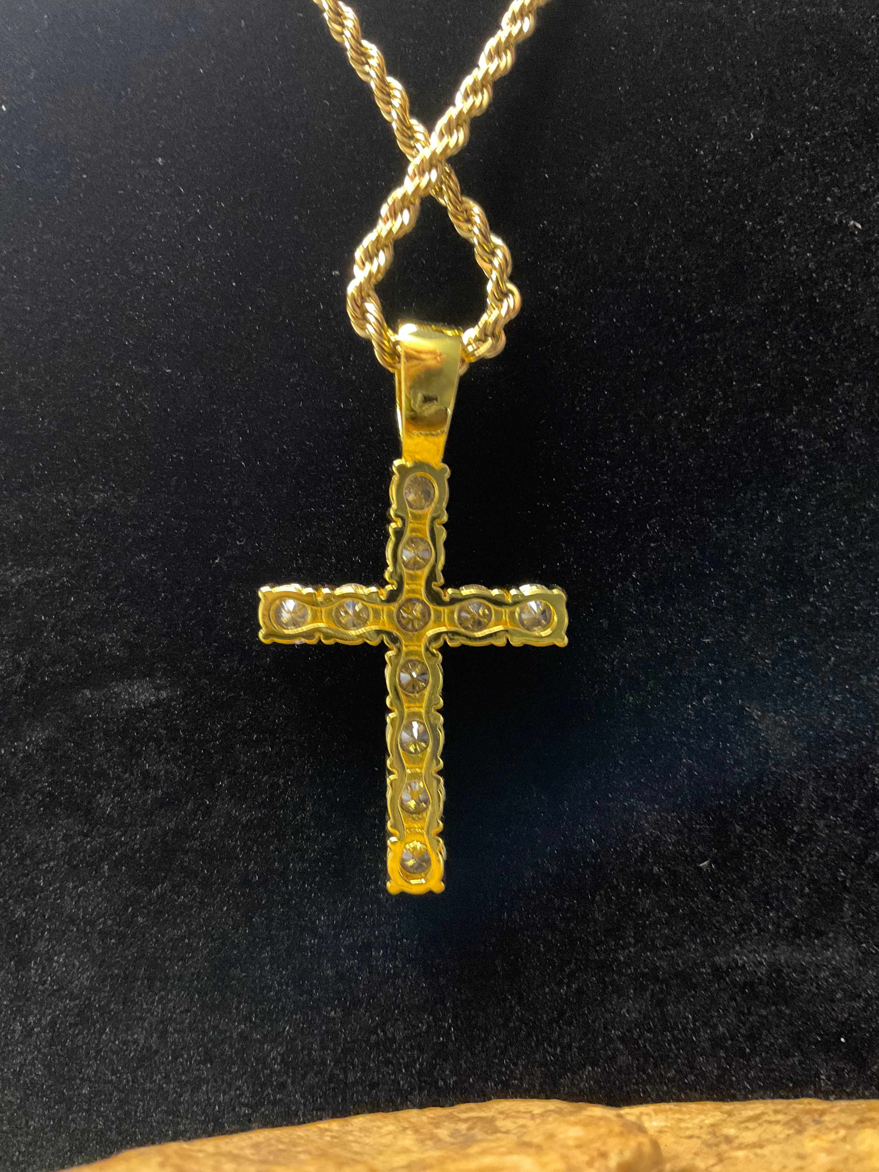 Gold cross pendant with diamonds on a black background