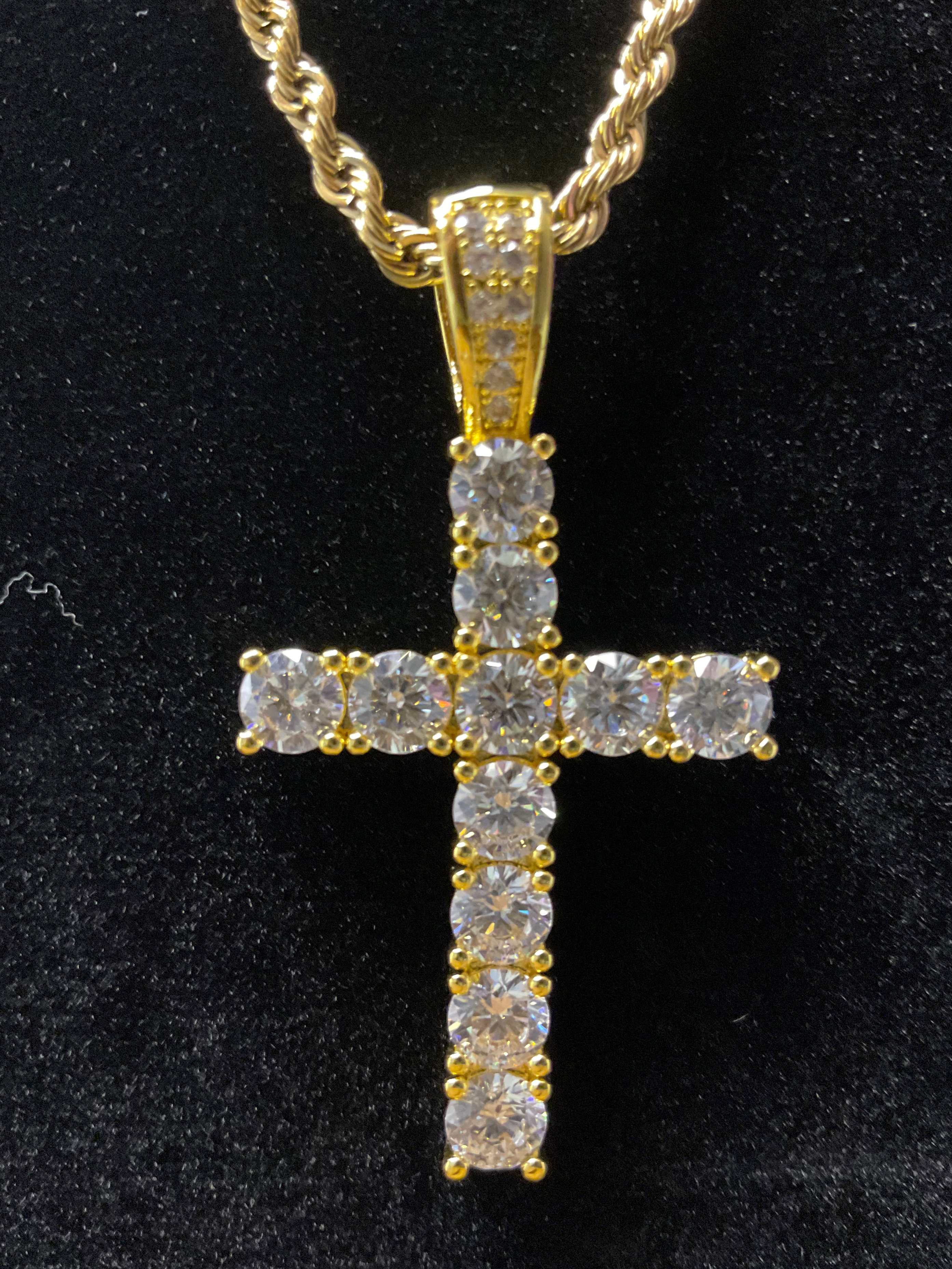 Gold cross pendant with diamonds on a black background