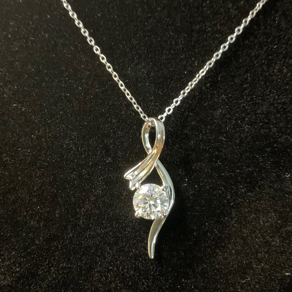 Silver necklace with a diamond pendant on a black background