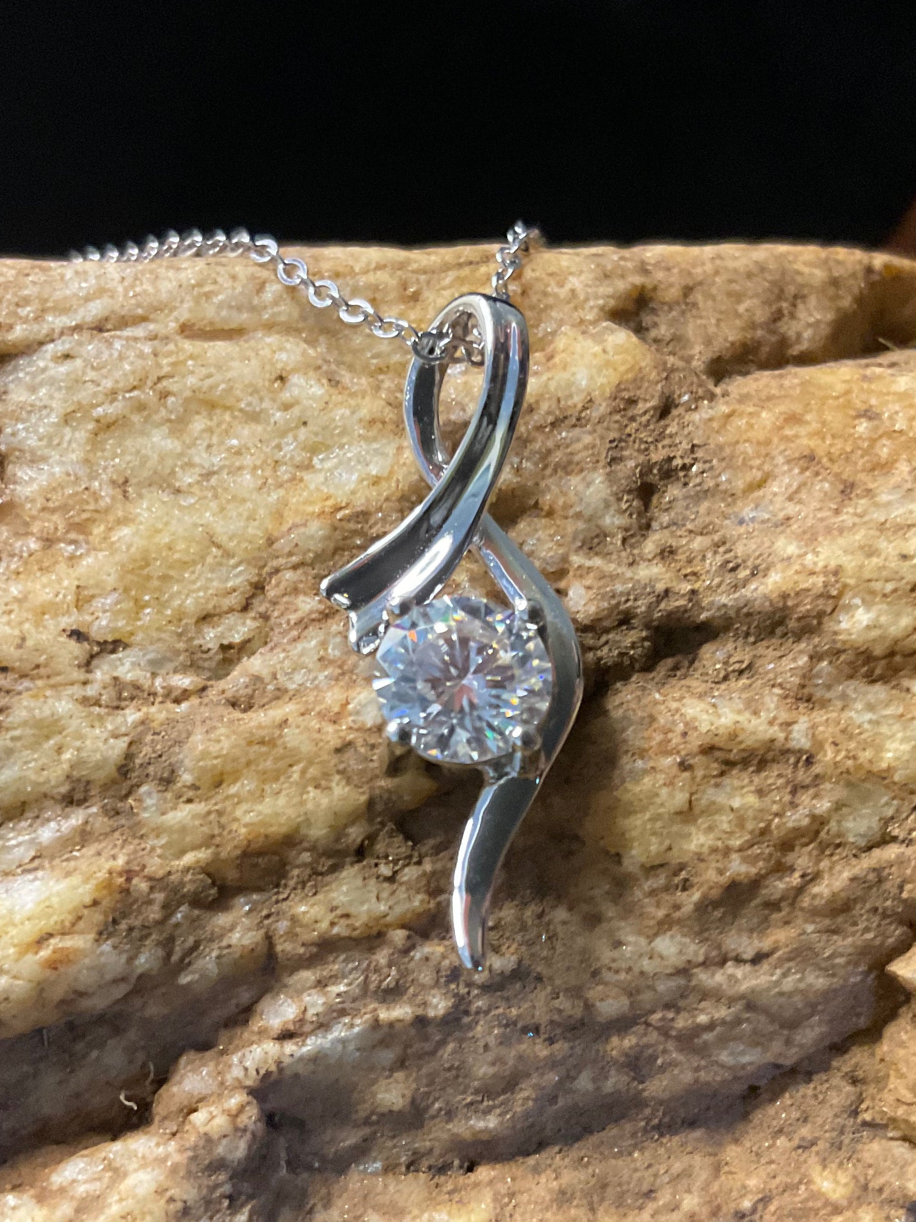 Silver pendant with a diamond on a rock