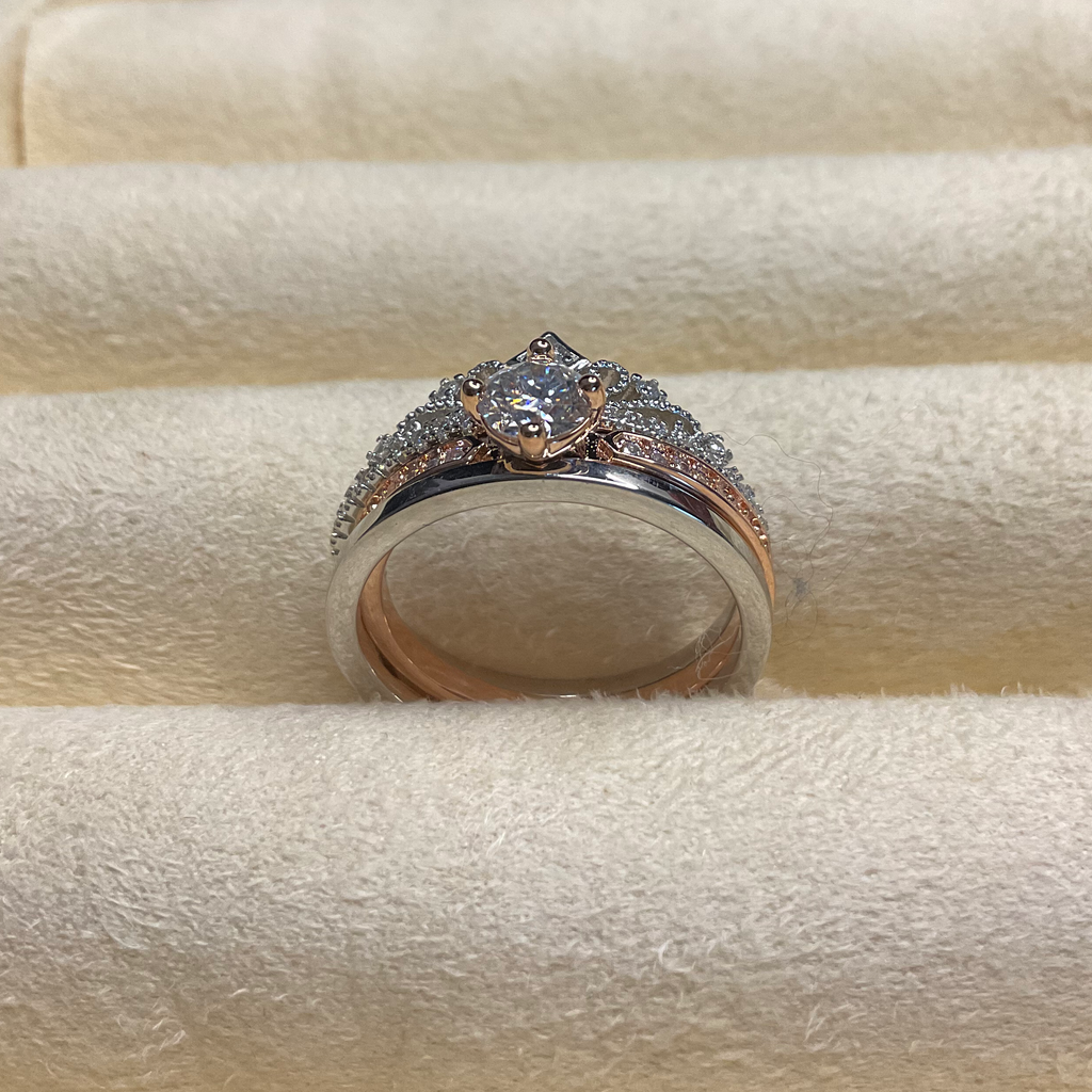 Rose gold ring with a diamond on a beige jewelry display