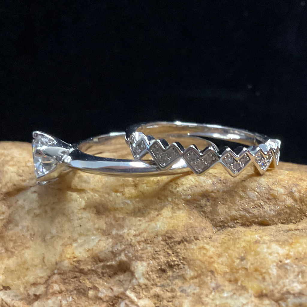 Silver ring with a heart design on a textured rock surface