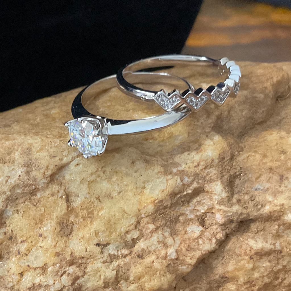 Two silver rings on a textured stone surface