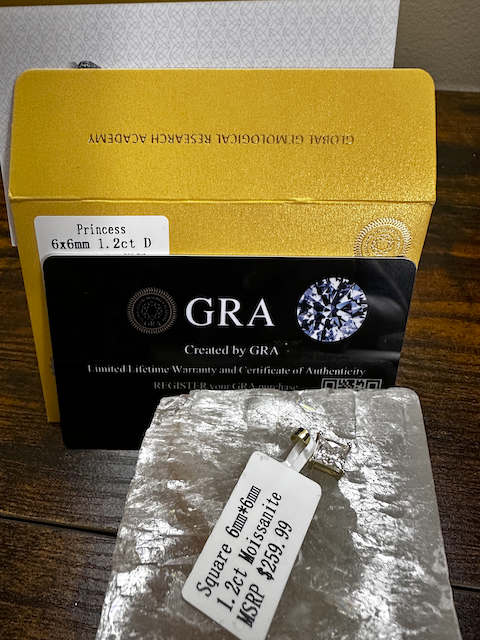 Diamond with GRA certification and packaging on a wooden surface