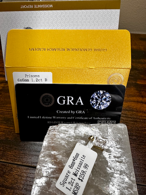 Diamond earring with GRA certification and packaging on a wooden surface