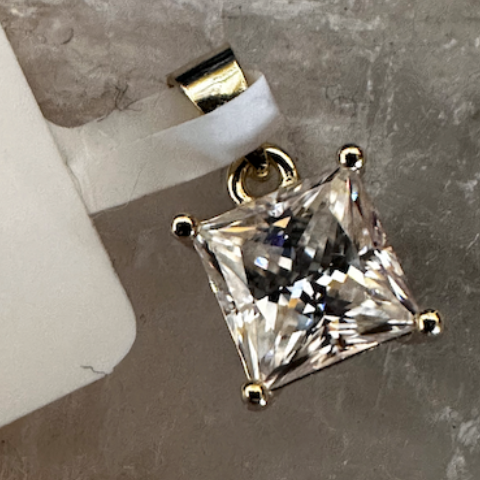 Diamond pendant on a gray stone surface