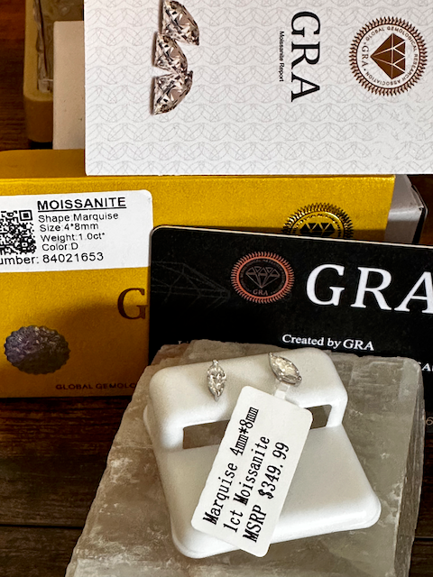 Diamond earrings with a GRA branded box and label on a wooden surface