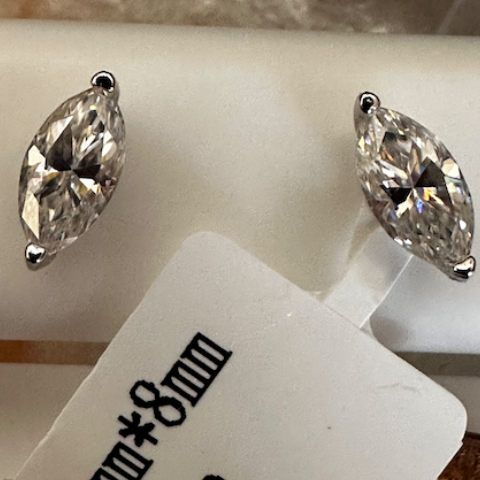 Marquise-shaped crystal earrings on a white card with product details.
