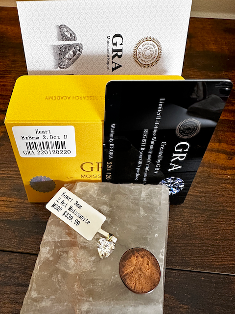 Diamond earrings with GRA (Gold Reserve Association) packaging on a wooden surface
