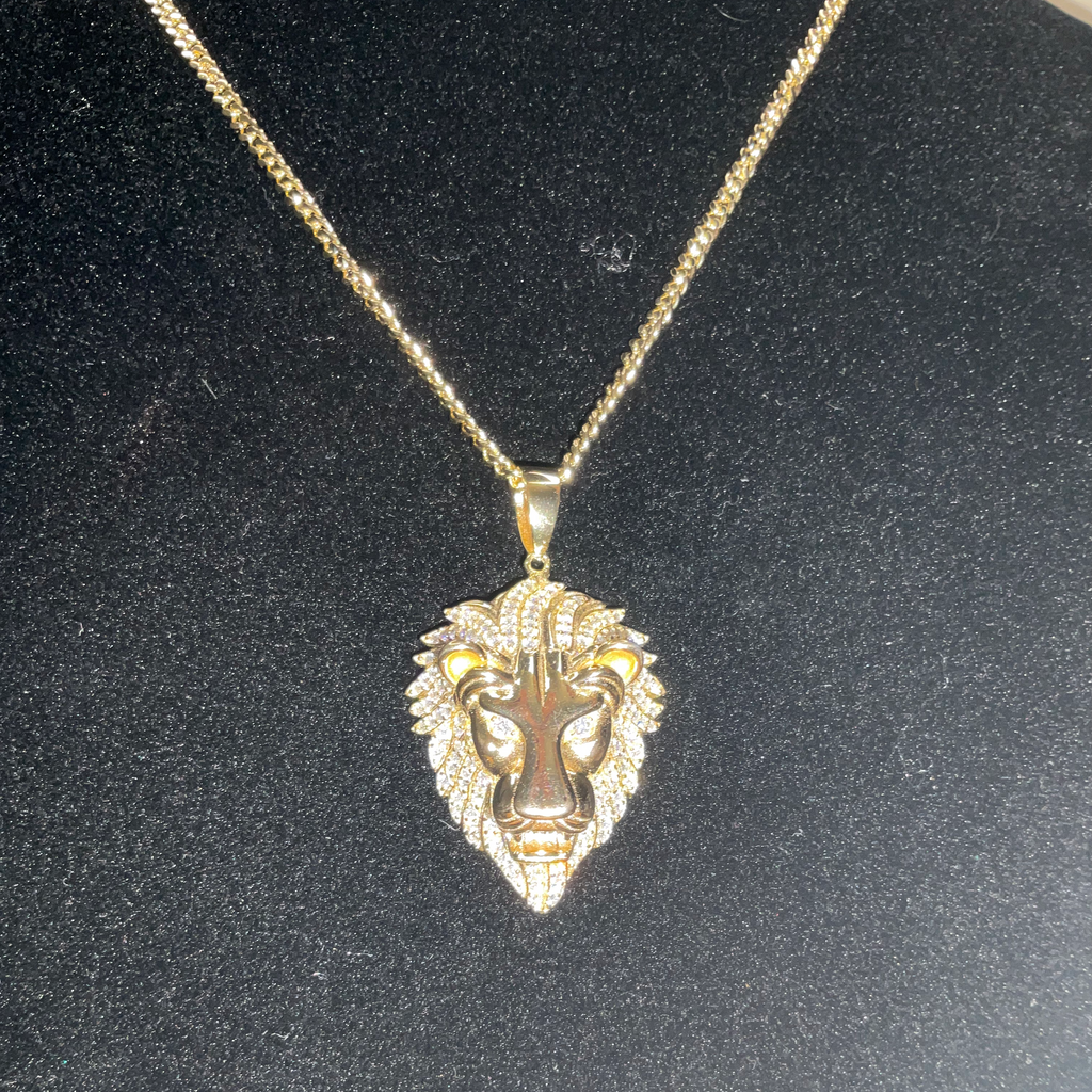 Gold lion head pendant necklace on a black background