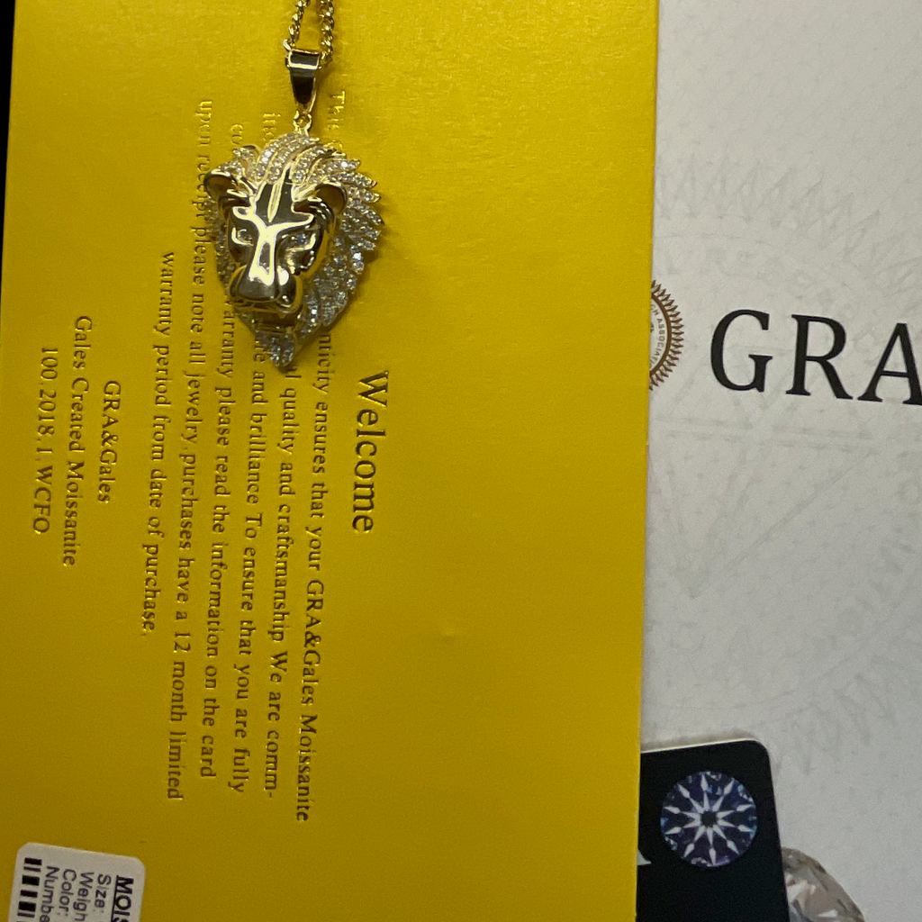 Gold lion pendant necklace on a yellow and white background