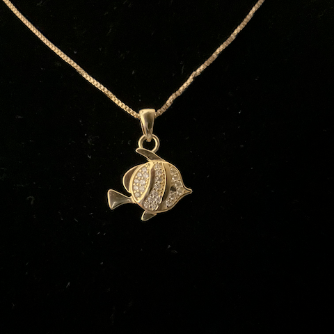 Gold fish-shaped pendant on a chain against a black background
