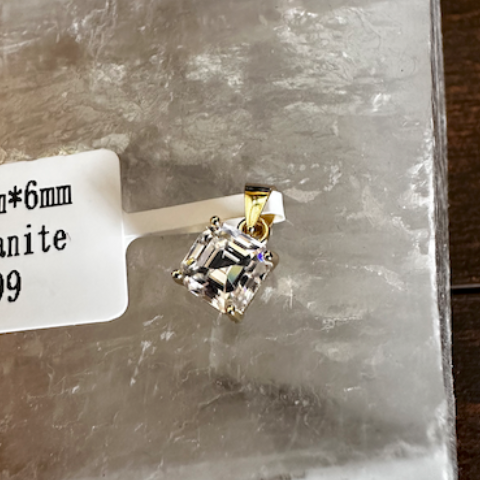 Loisianite stone with gold prong setting on a clear plastic bag, with a GRA branded box in the background.