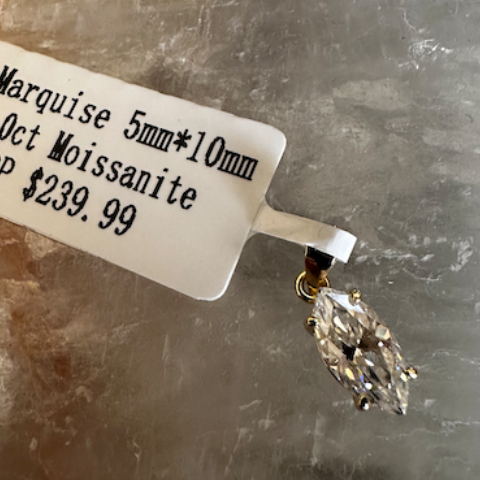 Marquise-shaped gemstone with a label on a textured surface