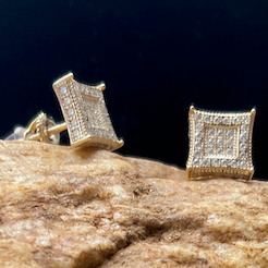 Silver square stud earrings on a textured stone surface