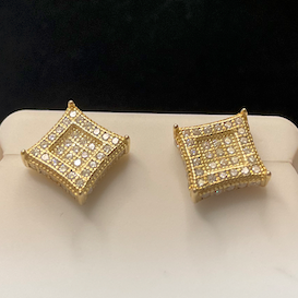 Gold square earrings on a white stand with a dark background