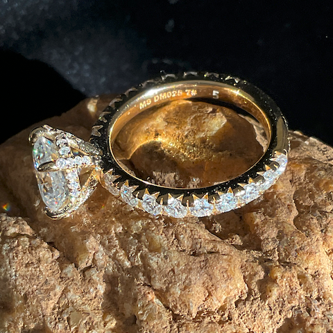 Gold ring with diamond accents on a textured stone surface
