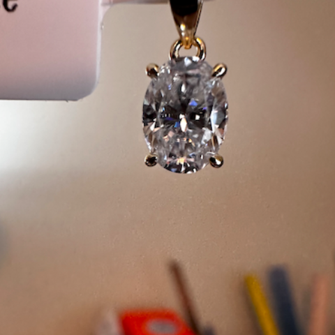 Diamond pendant on a stand with a blurred background